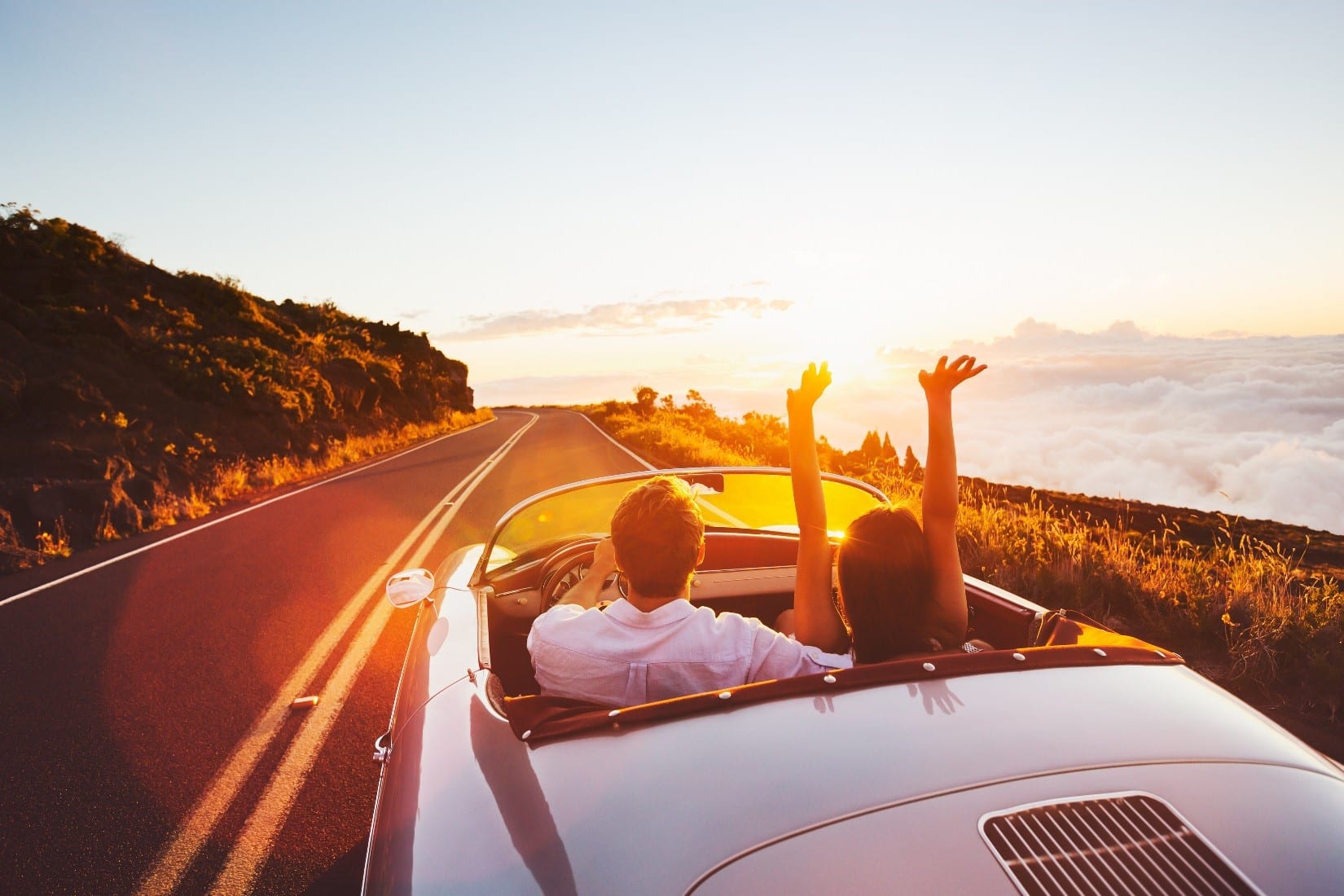 two people in a convertible car