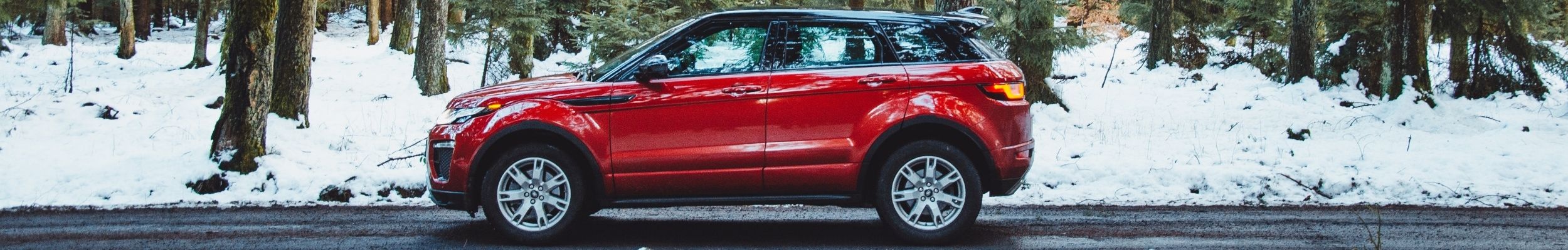 Red SUV in Snowy Forest