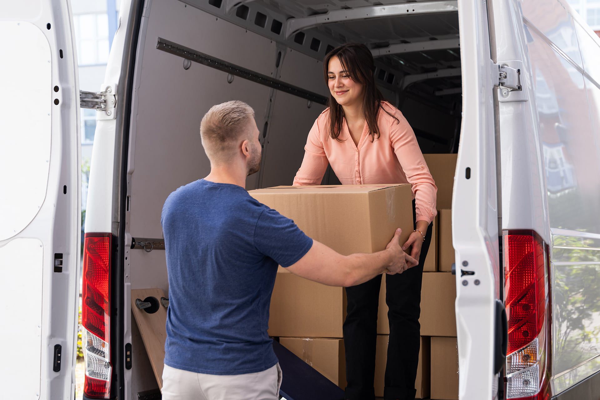 Couple unloading boxes from a van