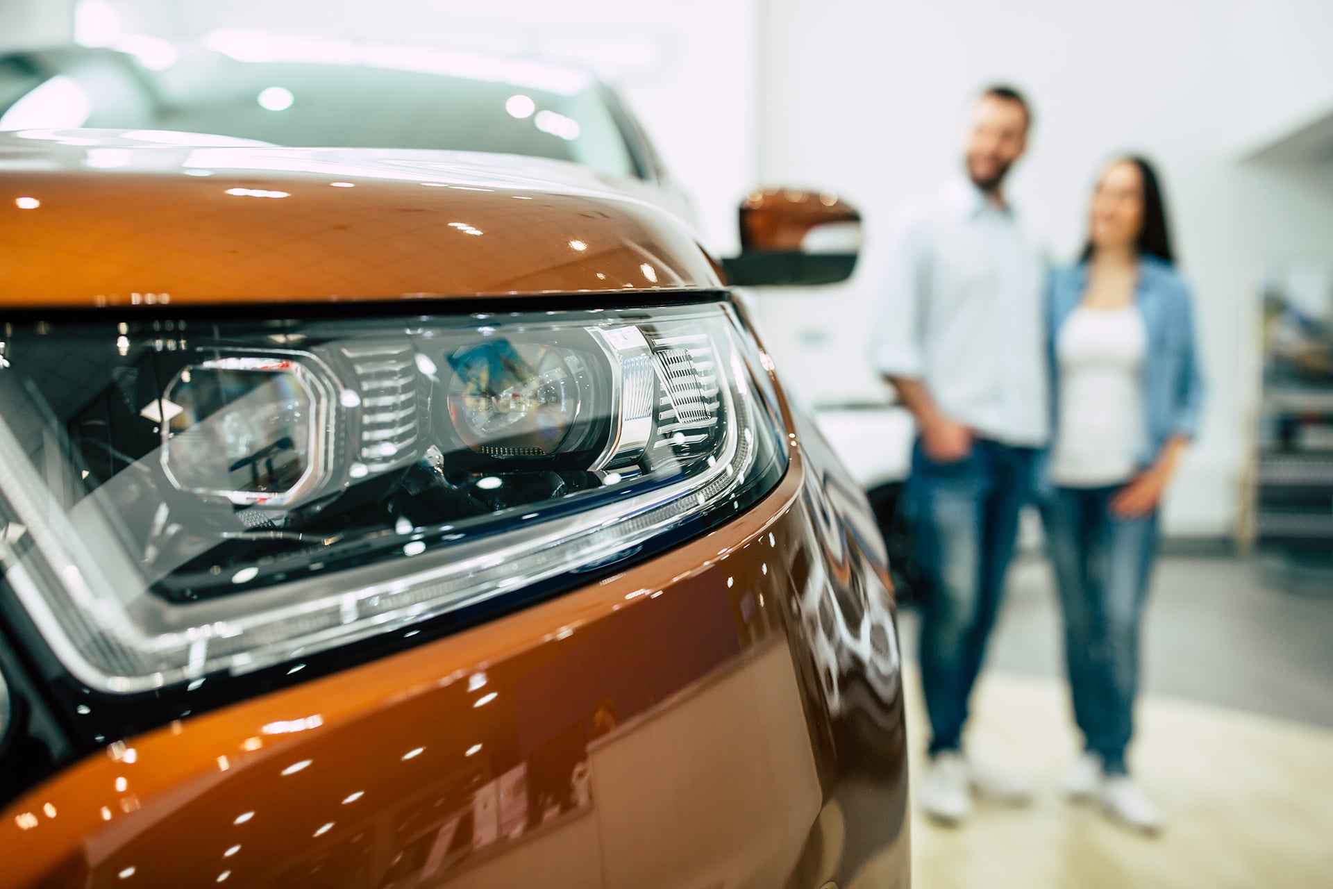 A couple looking at a new car